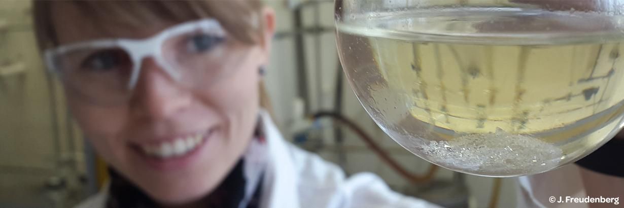 Wissenschaftlerin begutachtet Inhalt eines Reagenzglases